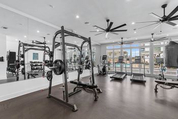 A gym with a variety of equipment including treadmills, weights, and exercise machines.
